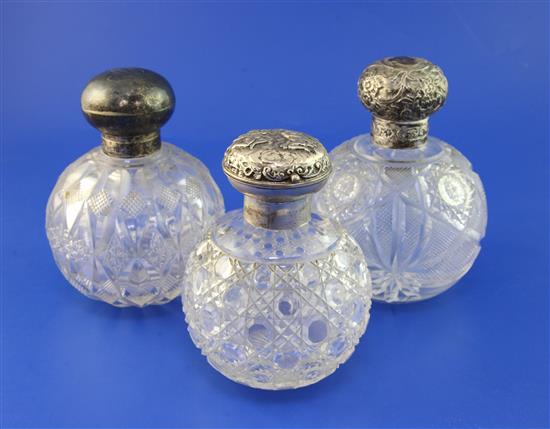 Three early 20th century silver lidded cut glass globular scent bottles, 5.75in et infra.